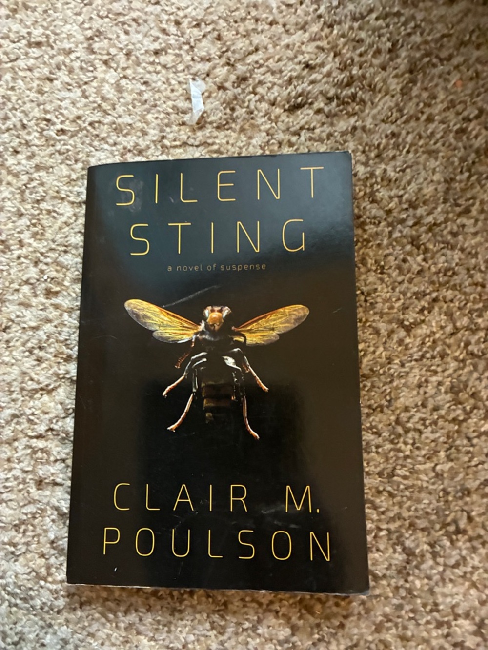 Silent Sting by Clair M. Poulson - Black Cover with Gold Insect Accent
